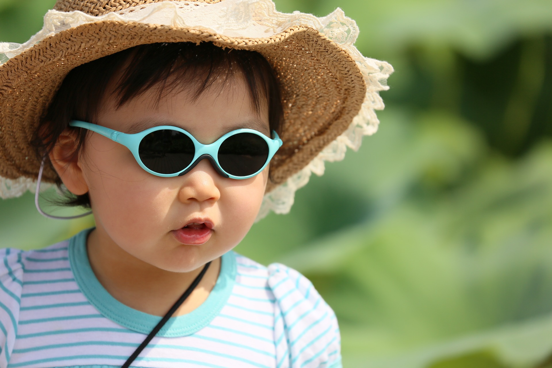 young child in protective sunglasses with wide brimmed hat